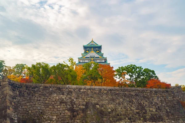 Osaka Castle building with colorful maple leaves or fall foliage
