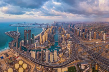 Dubai Marina ve otoyollarının havadan görünüşü, şehir merkezindeki ufuk çizgisi, Birleşik Arap Emirlikleri veya Uae. Finansal bölge ve şehir merkezindeki iş alanı. Gün batımında gökdelen ve yüksek binalar.