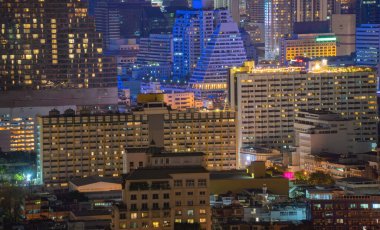 Ofis binalarının pencereleri geceleri aydınlatılır. Kentsel şehirde yansıması ile Cam mimarisi cephe tasarımı ile Aydınlatma, Finans bölgesinde Downtown Singapore City.