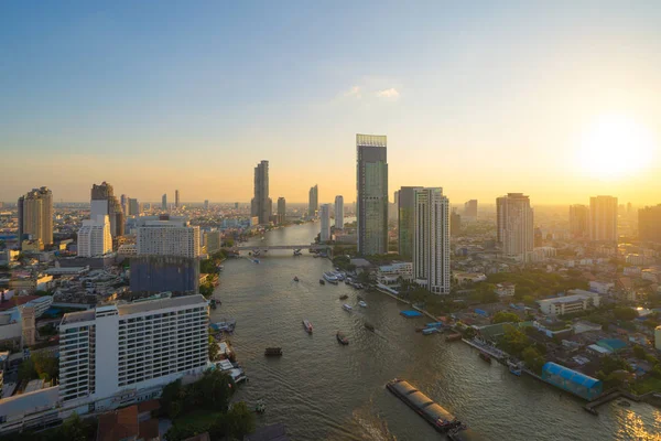 Chao Phraya Nehri ile tekneler ve Taksin Köprüsü havadan görünümü, Bangkok Downtown. Tayland. Akıllı şehir merkezinde finans bölge ve iş merkezleri. Gün batımında gökdelen ve yüksek katlı binalar.