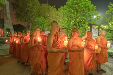 Pathum Thani City,Thailand - 02/06/2020 : Unidentified people. Thai Novice or monk in a buddhist ceremony where people walk with lighted candles in hand around a temple at night in Makha Bucha Day.