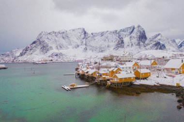 Reine City, Lofoten Adaları, Nordland, Norveç, Avrupa 'daki Norveç balıkçı köyünün havadan görünüşü. Beyaz karlı dağ tepeleri, kış mevsiminde doğa manzarası. Meşhur turistik cazibe