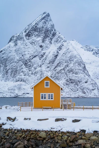 stock image Home, cabin or house, Norwegian fishing village in Reine City, Lofoten islands, Nordland county, Norway, Europe. White snowy mountain hills, nature landscape background in winter season.