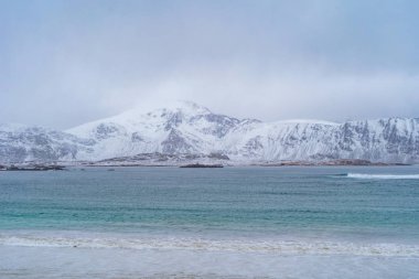 Lofoten Adaları, Nordland Bölgesi, Norveç, Avrupa. Beyaz karlı dağ tepeleri ve ağaçlar, kış mevsiminde doğa manzarası. Meşhur turistik cazibe