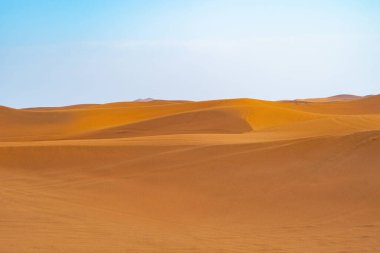 Dubai 'de kum tepecikli Kızıl Çöl Safarisi, Birleşik Arap Emirlikleri veya BAE. Gün batımında doğal manzara. Ünlü turist eğlencesi. Kumun mavi gökyüzü deseni.