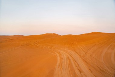 Dubai 'de kum tepecikli Kızıl Çöl Safarisi, Birleşik Arap Emirlikleri veya BAE. Gün batımında doğal manzara. Ünlü turist eğlencesi. Kumun mavi gökyüzü deseni.