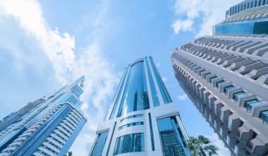 Yüksek binalara, gökdelenlere, mavi gökyüzü olan finans bölgesindeki mimarilere bakıyorum. Şehir merkezi Dubai, BAE 'de iş ve teknoloji konsepti için akıllı şehir..
