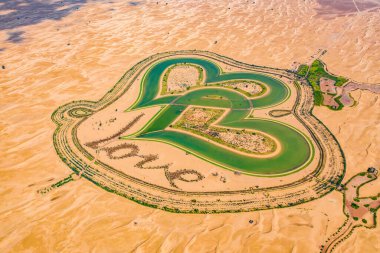 Aşk gölü ve kum çölünün havadan görünüşü Dubai 'deki Al Qudra, Birleşik Arap Emirlikleri veya BAE' deki Kalp şekilli göller. Sevgililer Günü için yeni bir turistik yer. Doğal manzara arka planı