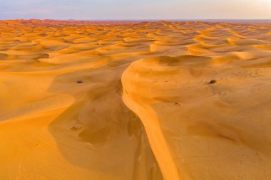 Dubai City, Birleşik Arap Emirlikleri veya BAE 'de kum tepecikli kırmızı çöl Safari manzarası. Gün batımında doğal manzara. Ünlü turist eğlencesi. Kum deseni. Üst görünüm.