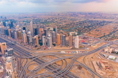 Dubai şehir merkezinin gökyüzü manzarası, Birleşik Arap Emirlikleri veya BAE 'deki karayolları veya caddeler. Finansal bölge ve şehir merkezindeki iş alanı. Gün batımında gökdelen ve yüksek binalar.