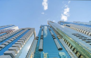 Yüksek binalara, gökdelenlere, mavi gökyüzü olan finans bölgesindeki mimarilere bakıyorum. Şehir merkezi Dubai, BAE 'de iş ve teknoloji konsepti için akıllı şehir..