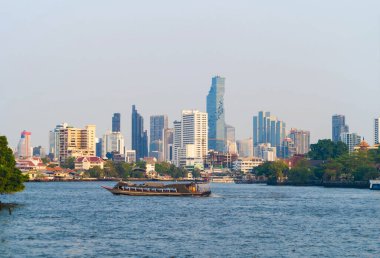 Chao Phraya Nehri 'nde tekneler geziyor. Bangkok' ta gökdelen binaları var. Şehir merkezi, mavi gökyüzü, Tayland. Mimari manzara geçmişi.