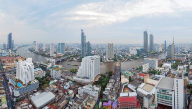 Chao Phraya Nehri ile tekneler ve Taksin Köprüsü havadan görünümü, Bangkok Downtown. Tayland. Akıllı şehir merkezinde finans bölge ve iş merkezleri. Gün batımında gökdelen ve yüksek katlı binalar.
