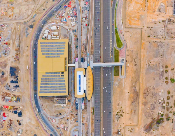 Aerial view of train terminal station with street road and sand desert in transportation concept in Dubai downtown, urban city, United Arab Emirates or UAE. Architecture background.