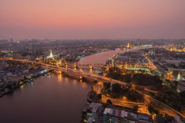 Beyaz Prayoon Pagoda, Memorial Köprüsü ve Phra Pok Klao Köprüsü 'nün günbatımında Chao Phraya Nehri' nin kıvrımlı binaları. Şehir merkezi, Bangkok, Tayland.