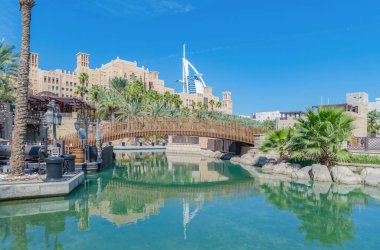 Burç Al Arap Jumeirah Adası ya da turkuaz gölü ya da nehir ya da yansıması olan tekne inşaatı, Dubai şehir merkezi silueti, Birleşik Arap Emirlikleri ya da BAE. Şehir merkezinde bir otel, öğle vakti tatil konseptinde..