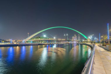 Hoşgörü köprüsü. Göl veya nehir ile mimari yapısı, Dubai şehir merkezi silueti, Birleşik Arap Emirlikleri veya BAE. Geceleri şehir merkezindeki finans bölgesi ve iş alanı.