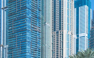 Ofis binalarının pencereleri. Şehir merkezi Dubai 'de cam mimari ön cephe tasarımı. Mavi gökyüzü ile finans bölgesinde şehir.