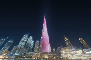 Dubai şehir merkezindeki Burj Halife gökyüzü ve çeşme, Birleşik Arap Emirlikleri veya BAE. Finansal bölge ve şehir merkezindeki iş alanı. Gün batımında gökdelen ve yüksek binalar.