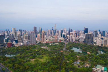 Lumpini Park 'taki yeşil ağaçların havadan görünüşü, Sathorn bölgesi, Bangkok şehir merkezi Skyline. Tayland. Asya 'nın akıllı kentindeki finans bölgesi ve iş merkezi. Gökdelen ve yüksek binalar
