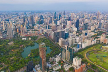 Lumpini Park 'taki yeşil ağaçların havadan görünüşü, Sathorn bölgesi, Bangkok şehir merkezi Skyline. Tayland. Asya 'nın akıllı kentindeki finans bölgesi ve iş merkezi. Gökdelen ve yüksek binalar