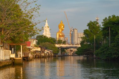 Phasi Charoen bölgesindeki Wat Paknam Phasi Charoen Tapınağı 'ndaki dev altın Buda. Tayland' ın Bangkok kentindeki Chao Phraya Nehri 'nde teknesi var..