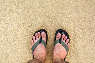 Ayakları üzerinde kum ve deniz