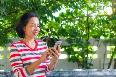 Orta yaşlı kadın telefon oynamak