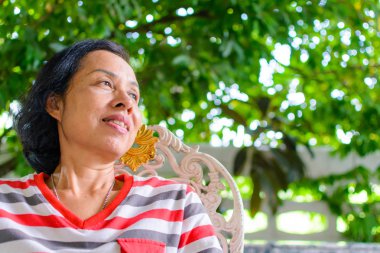 Orta yaşlı kadın gülümsüyor.