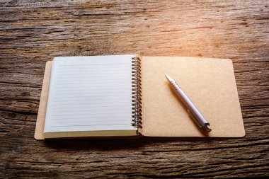 ahşap masa üstünde kalem ve kitap