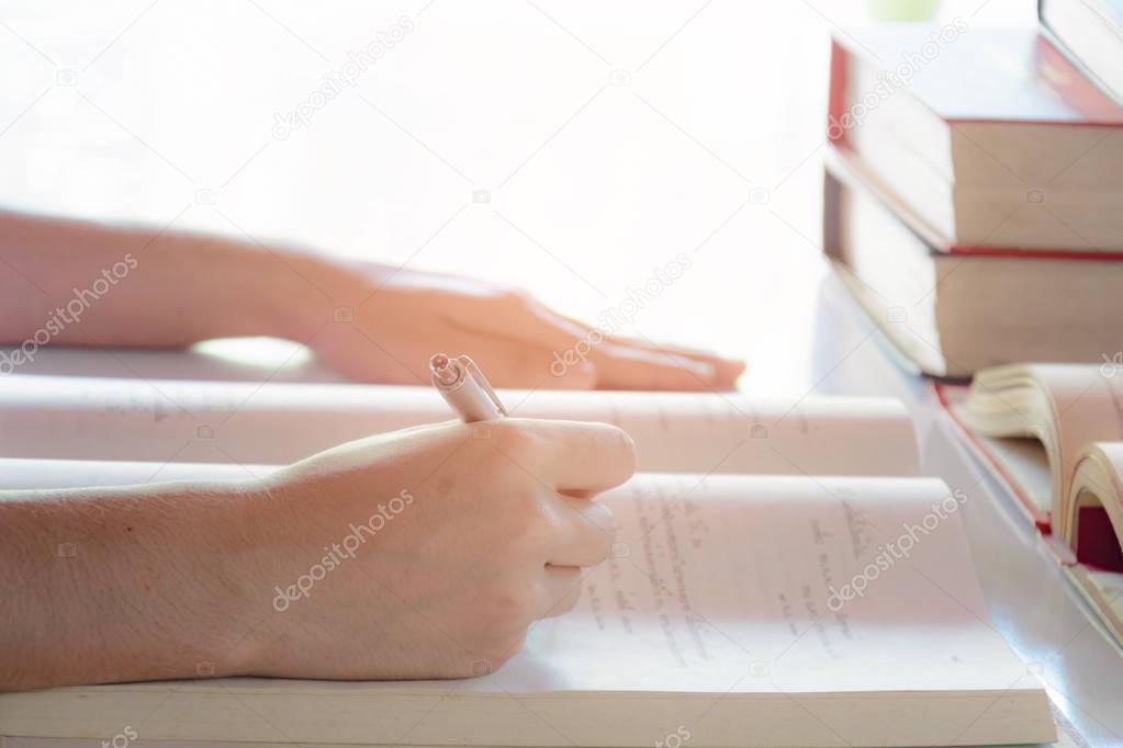 Man writing pen in book on white table