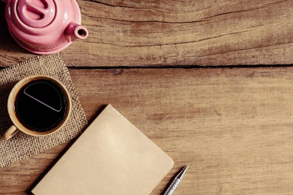 Morgenkaffee und Bücherstift auf altem Holztisch — Stockfoto