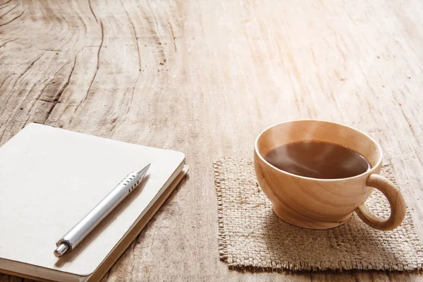 Morning coffee and book pen on old wood table — Stock Photo, Image