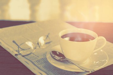 Kahve Kupası saat ve haber kağıt üzerinde eski ahşap masa