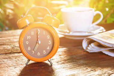 Kahve Kupası saat ve haber kağıt üzerinde eski ahşap masa