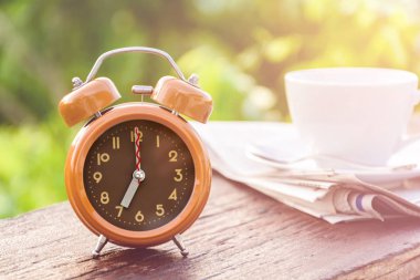 Kahve Kupası saat ve haber kağıt üzerinde eski ahşap masa