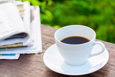 Kahve Kupası saat ve haber kağıt üzerinde eski ahşap masa