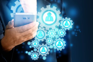 bir cep telefonu tutan ve bir wifi simgesi olan siyah bir takım elbise giyen Bayan