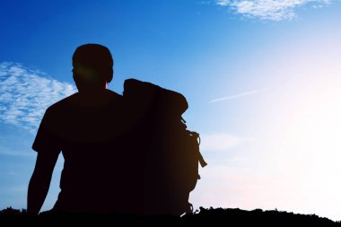 güneşi bakmak için omuz çantalı adam siluet