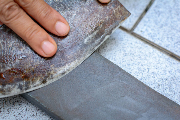 close up hand with Knife sharpener on rock