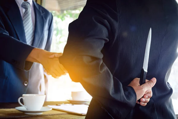 Geschäftsleute halten Messer mit Handschlag zurück — Stockfoto