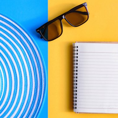 Mavi şapka ve güneş gözlüğü renkli kağıt üzerinde