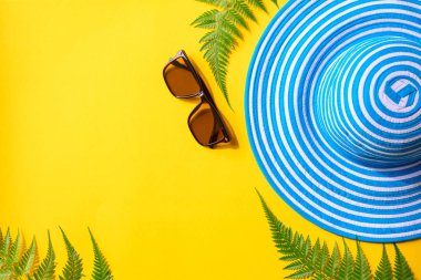 Mavi şapka ve güneş gözlüğü renkli kağıt üzerinde