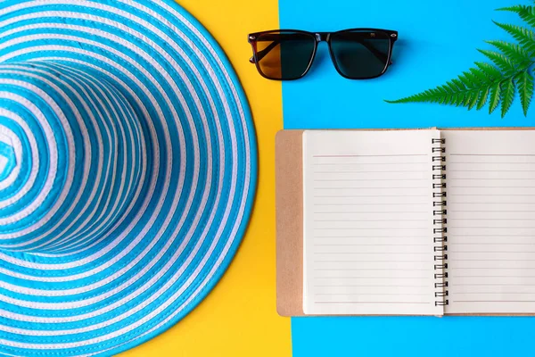 Blauwe hoed en zonnebril op kleurrijke papier — Stockfoto