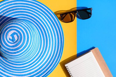 Mavi şapka ve güneş gözlüğü renkli kağıt üzerinde