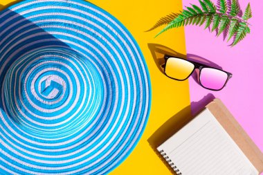 Mavi şapka ve güneş gözlüğü renkli kağıt üzerinde