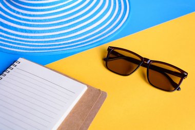 Mavi şapka ve güneş gözlüğü renkli kağıt üzerinde