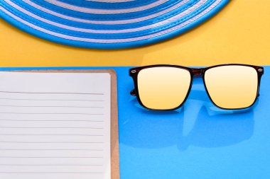 Mavi şapka ve güneş gözlüğü renkli kağıt üzerinde