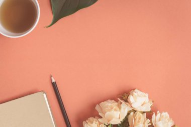 Düz yatıyordu defter ve gül kırmızı bir masa üzerine yerleştirilen