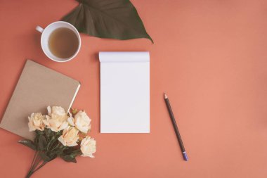 Düz yatıyordu defter ve gül kırmızı bir masa üzerine yerleştirilen